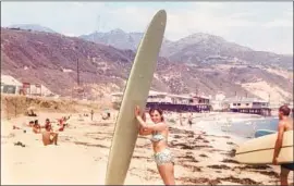  ?? Photograph from Kathy Zuckerman ?? ZUCKERMAN with her surfboard on a Malibu beach, circa 1959. “I didn’t want to be the girl on the beach looking at the men,” she recalls. “I wanted to surf.”