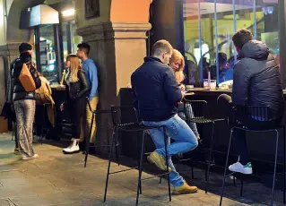  ??  ?? Al bar
Clienti fuori da un locale sotto i portici di piazza Pontida nelle prime fasi del Covid. Anche allora ci fu uno scontro sulla chiusura anticipata dei locali