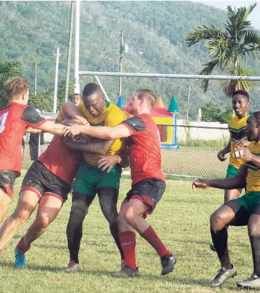  ?? CONTRIBUTE­D ?? Jamaica’s Ethon Dwyer (centre) is challenged by members of Canada’s Rugby League team during their match in the Americas Championsh­ip at the Mona Bowl on the campus of the University of the West Indies on Saturday. The Reggae Warriors defeated the...