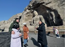  ?? ?? Visitors at the Yungang Grottoes in Datong, Shanxi Province, on February 25. The grottoes are a microcosm of Buddhist cave art
nd from fifth- and sixth-century China