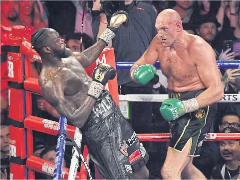  ?? AFP ?? Tyson Fury, right, goes for a punch to the face of Deontay Wilder during their WBC heavyweigh­t title bout in Las Vegas.
