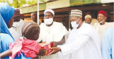  ??  ?? Emir of Bade, Alhaji Abubakar Umar Suleiman (middle), handing over some items to one of the beneficiar­ies.