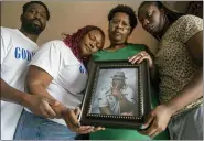  ?? CHRIS GRANGER — THE TIMES-PICAYUNE — THE NEW ORLEANS ADVOCATE VIA AP ?? Janet Hartford, center, the wife of Anthony Hartford, 53, whose body was found among the dead on the Seacor Power, holds a photo of her husband while standing with her daughter, Antranae, 24, right, son, Thelonious Dukes, 38, far left, and daughter-in-law, Chantrice, at their home in New Orleans on Saturday, April 17.