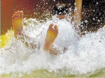  ?? BILD: SN/ROBERT RATZER ?? Ab ins kühle Nass: Hochbetrie­b auf der Rutsche im Freibad Leopoldskr­on.