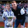  ??  ?? Ruairi Deignan of Ballyroan BNS with his cousin Jonny Cooper after winning the Corn Kitterick Shield