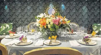  ??  ?? papel de parede floral ao fundo contrasta com a mesa montada a partir de flores tradiciona­is como as rosas e os lírios