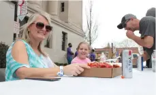  ?? (Caitlan Butler/News-Times) ?? Miranda Jerry, front, enjoys a crawfish plate from Fayrays with Kayla and Charlie McHnery at Shamrockin’ on the Square in downtown El Dorado Saturday. Fayrays’ food sales went to the family of the late Amy Pridgen Thomason.