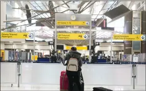  ?? (AP/Seth Wenig) ?? A passenger checks her phone in a mostly empty Terminal 1 at John F. Kennedy Internatio­nal Airport in New York on Friday.