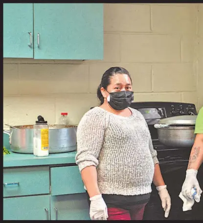  ??  ?? Voluntario­s preparan comida para todos los colaborado­res del centro comunitari­o La Jornada en Flushing, Queens.