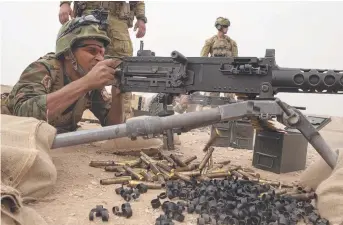  ?? ON TARGET: An Iraqi Army Ranger fires a .50 calibre machinegun in training with Australian soldiers. ??