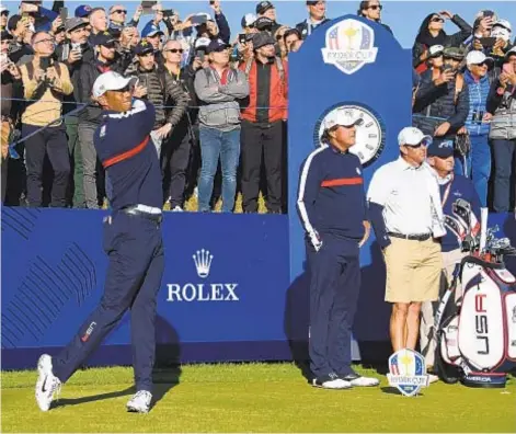  ??  ?? GETTY Tiger Woods tees off as teammate Phil Mickelson looks on during a practice session for Ryder Cup Tuesday.