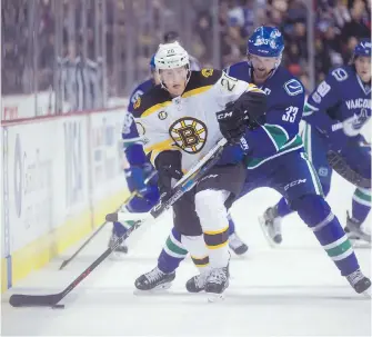  ?? DARRYL DYCK, THE CANADIAN PRESS ?? Bruins centre Riley Nash tries to fend off Canucks centre Henrik Sedin during the second period in Vancouver on Monday night.