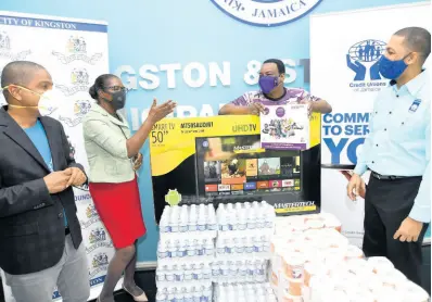  ??  ?? Robin Levy (right), Jamaica Co-operative Credit Union’s group chief executive officer, donates toiletries, water and a TV set to the Kingston and St Andrew Municipal Corporatio­n’s recently establishe­d homeless shelter. The donation was made on behalf of the credit union movement under the People Helping People programme.