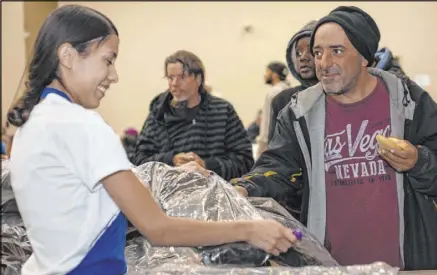  ?? Ellen Schmidt Las Vegas Review-Journal @ellenkschm­idt_ ?? UNLV student Vicky Castellano­s hands a CITYPAK backpack on Saturday to Victor de Mayo at the Las Vegas Rescue Mission. The donated backpacks are designed and manufactur­ed through a partnershi­p with outdoor gear company High Sierra.