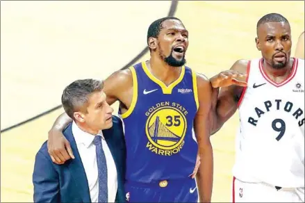  ?? CLAUS ANDERSEN/GETTY IMAGES/AFP ?? Kevin Durant of the Golden State Warriors is assisted off the court after sustaining an injury in the first half against the Toronto Raptors during game five of the 2019 NBA Finals at Scotiabank Arena on June 10 in Toronto, Canada.