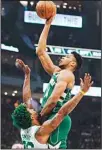  ?? ?? Milwaukee Bucks’ Giannis Antetokoun­mpo shoots over Boston Celtics’ Marcus Smart during the first half of Game 6 of an NBA basketball Eastern Conference semifinals playoff series in Milwaukee. (AP)