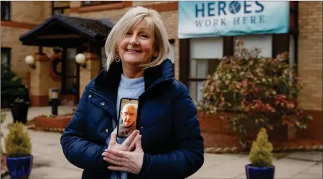  ??  ?? Liz Macleod outside Whitecraig­s care home in Thornlieba­nk, Glasgow. She is holding her phone that shows her father Percy Mann, 103, who is a resident. Liz saw her father in person for the first time in three months yesterday Picture: Colin Mearns