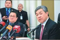  ?? KING CHAI / AP ?? Malaysian Deputy Prime Minister Ahmad Zahid Hamidi (right) tells reporters about suspects arrested in the death of Kim Jong-nam, the half brother of DPRK top leader Kim Jong-un. Hamidi spoke at a news conference Thursday in Putrajaya, Malaysia.