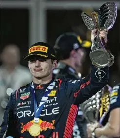  ?? KAMRAN JEBREILI/ASSOCIATED PRESS ?? Red Bull driver Max Verstappen of the Netherland­s hoists the victory trophy after winning the Abu Dhabi Formula One Grand Prix race Sunday at the Yas Marina Circuit in the United Arab Emirates.