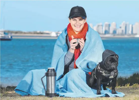  ?? Picture: RICHARD GOSLING ?? Amelia Stone makes sure she keeps warm during a morning at the Broadwater with her French Bulldog Ava.