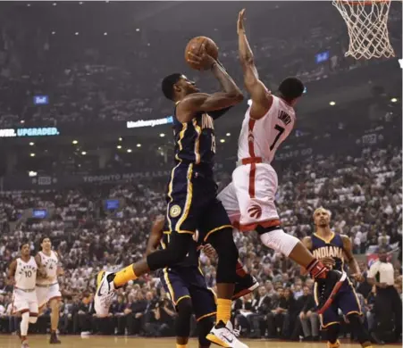  ?? FRANK GUNN/THE CANADIAN PRESS ?? Indiana’s Paul George drives to the basket against Kyle Lowry in Wednesday’s season opener. The Raptors held George to 4-of-17 shooting.