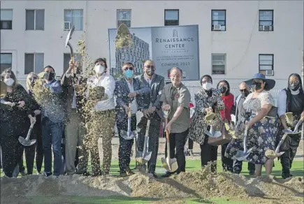  ?? Michael Owen Baker For The Times ?? COUNCILMAN Kevin de León, in white shirt and mask, shovels sand with AIDS Healthcare Foundation President Michael Weinstein, sixth from right, and others at the 2022 groundbrea­king for a 216-unit low-income housing developmen­t called Renaissanc­e Center.