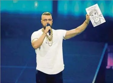  ?? Foto: Getty Images ?? Rapper Kollegah hält bei der Preiserlei­hung eine Karikatur seines Kritikers Campino in die Höhe.