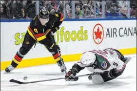  ?? Ethan Cairns The Associated Press ?? Canucks winger Brock Boeser (6) and Coyotes defenseman Michael Kesselring vie for the puck in Vancouver, British Columbia.