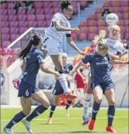  ?? Alex Goodlett / Getty Images ?? Simone Charley, second from left, and Lindsey Horan, right, of the Portland Thorns jump over the North Carolina Courage’s Mccall Zerboni for a header during the first round of the NWSL Challenge Cup at Zions Bank Stadium on Saturday in Herriman, Utah.