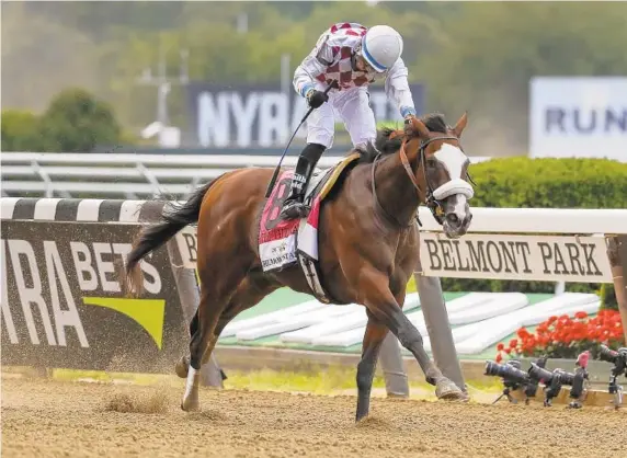  ?? SETH WENIG/AP PHOTOS ?? Manny Franco starts to celebrate as he guides Tiz the Law to a four-length victory Saturday in the first leg of the Triple Crown, the 152nd running of the Belmont Stakes in New York.