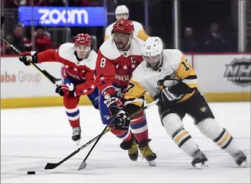  ?? Toni L. Sandys/Washington Post ?? The Penguins’ Bryan Rust steals the puck from Alex Ovechkin Sunday at Capital One Arena.