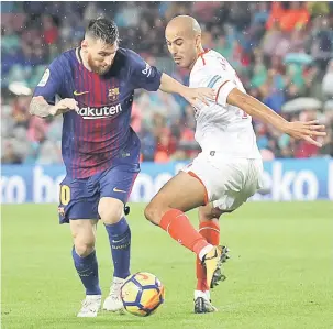 ?? — Gambar AFP ?? SUKAR DIKAWAL: Messi (kiri) berdepan saingan sengit daripada pemain Sevilla pada aksi La Liga Sepanyol di Nou Camp, Barcelona Sabtu lepas.