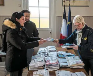  ?? PHOTO : N. MONTARD, OUEST-FRANCE ?? Les habitants de La Calotterie, dont les maisons sont inaccessib­les, défilent dans le bureau de poste temporaire pour récupérer leur courrier.|