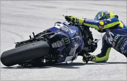  ??  ?? CAÍDA. Valentino Rossi se fue al suelo cuando lideraba la carrera y Márquez le recortaba tiempo.