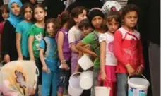  ?? FADI AL-HALABI/AFP/GETTY IMAGES FILE PHOTO ?? Syrian children line up to receive food in Aleppo. Joe Fiorito encourages the public to help refugees and dispel prejudices about them.