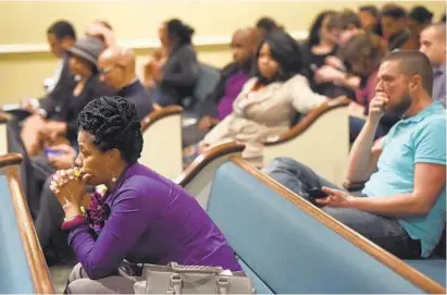  ?? KIM HAIRSTON/BALTIMORE SUN ?? Monique Smith, left, of Hamilton and Brian Seel of Upper Fells Point listen during a community forum at Mount Pleasant Church to update residents about progress on the federal consent decree affecting the Baltimore Police Department.