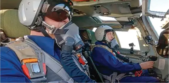 ?? ?? Hot seat: Wearing a flightsuit and helmet, Vladimir Putin sits at the controls of a Russian Tu-160M supersonic warplane yesterday