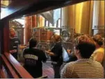  ??  ?? Iron Hill Brewery & Restaurant Head Brewer Will Mink, at left, leads a tour of the Phoenixvil­le brewing process for Kimberton Fire Company members. Iron Hill will release Tower 61 beer next week during an event that will benefit the fire company.