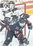  ??  ?? Niagara IceDogs Akil Thomas (12) is checked by Peterborou­gh Petes Matthew Timms (4) in OHL hockey action Feb. 3 at the Meridian Centre in St. Catharines.