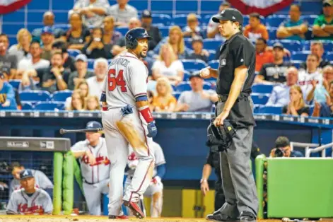  ?? PHOTOS BY THE ASSOCIATED PRESS ?? Atlanta Braves left fielder Emilio Bonifacio reacts toward home plate umpire John Tumpane after striking out during the eighth inning of Tuesday’s game in Miami. The Marlins defeated the Braves 8-4.