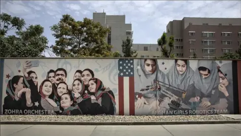  ?? Paula Bronstein/Getty Images ?? Murals are seen along the walls at a quiet U.S. embassy on Friday in Kabul, Afghanista­n. More than 200 Afghan nationals who assisted American troops were evacuated on the first of many flights headed to Fort Lee military base in Virginia.