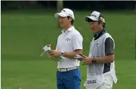  ?? AFP ?? Ryo Ishikawa (left) and his caddy look out along the fairway during round two of the Singapore Open. —
