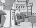  ??  ?? The original Sanders Cafe sign, dwarfed by a newer KFC sign and bucket, that tower over the Corbin, Ky., restaurant.