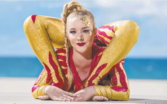  ?? Picture: JERAD WILLIAMS ?? Pink Flamingo contortion­ist Jordan McKnight makes herself comfortabl­e at Kurrawa Beach.