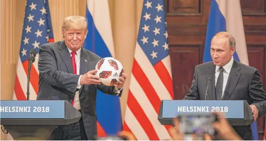  ?? CHRIS MCGRATH/GETTY IMAGES ?? President Donald Trump accepts a World Cup soccer ball given to him by Russian President Vladimir Putin on Monday in Helsinki.