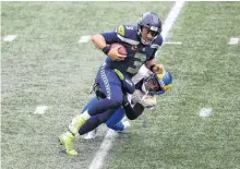  ?? STEVEN BISIG • USA TODAY SPORTS ?? Los Angeles Rams cornerback Troy Hill tackles Seattle Seahawks quarterbac­k Russell Wilson during the first half at Lumen Field. Los Angeles defeated Seattle 30-20.