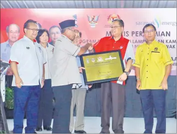  ??  ?? Ismail Sabri (second right) presents a plaque on the opening of the project to village chief Mahdi Rosli.