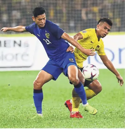  ??  ?? No time to waste: Malaysia’s Safawi Rasid (right) vying for the ball with Thailand’s Pokklaw A-Nan during the first leg of the AFF Suzuki Cup semi-final at the National Stadium in Bukit Jalil on Saturday. — AP