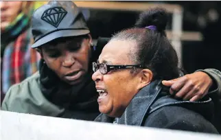  ?? JOHN MAHONEY ?? Erma Gibbs is comforted by daughter Tricia Gibbs as she cries out while speaking at a vigil outside the Montreal Police Brotherhoo­d office Monday by families of people who have been killed by police.