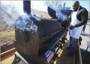  ?? (Arkansas Democrat-Gazette/Staton Breidentha­l) ?? Union Pacific Workforce Resource Manager Stephen Harris cooks on a locomotive-shaped grill Monday in the parking lot at War Memorial Stadium as employees from Union Pacific’s Black Employee Network serve food to the community after the Martin Luther King Jr. Day parade. More photos are available at arkansason­line.com/121mlk